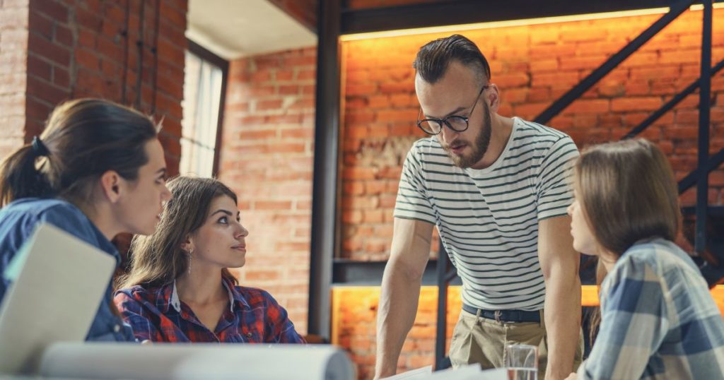 A team of marketers measuring brand awareness around a table.