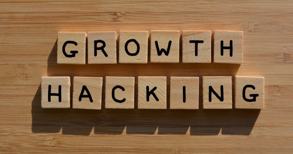 Wooden blocks with "Growth Hacking" written on them are standing on top of a wooden floor.