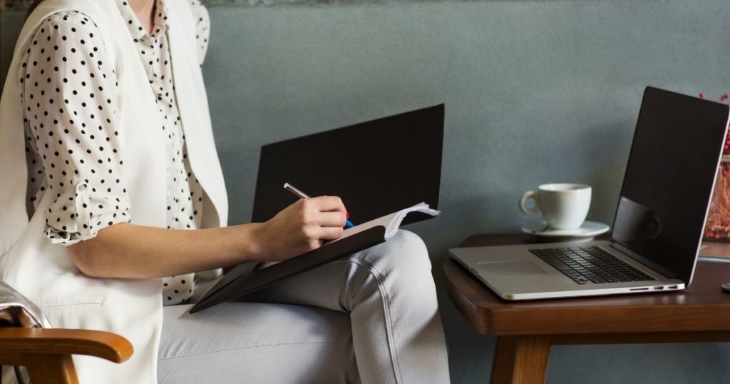 bir kadın laptop karşısında yazı yazıyor. 