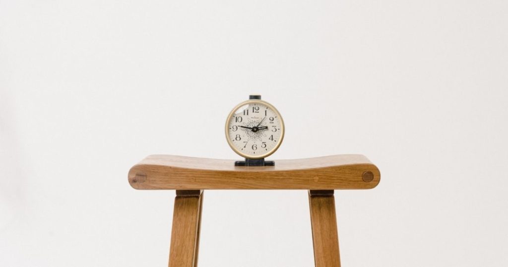 A clock on a wooden platform.
